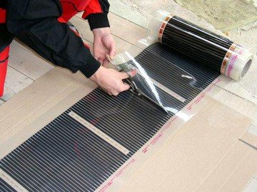 Lay the heated film floor on top, cutting off pieces of the required length from the roll in the places indicated by the scissors symbol.